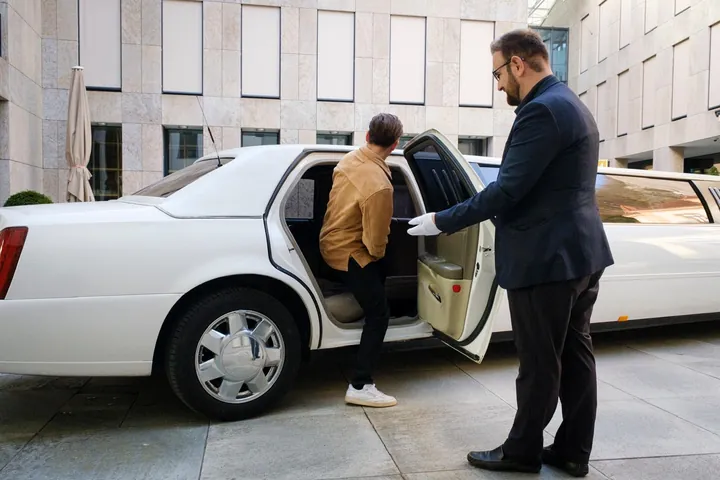 Taxi Leo Chauffeur an der Cadillac Stretchlimousine